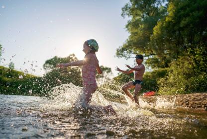 jeune fille et jeune garçon se baignant dans une rivière