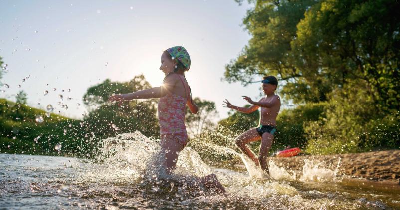 jeune fille et jeune garçon se baignant dans une rivière