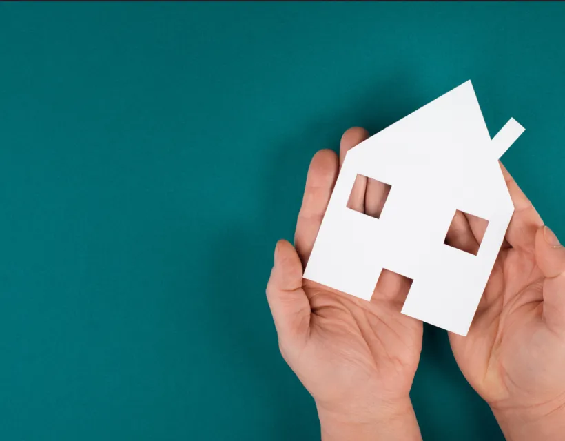 maison en papier dans deux mains